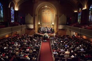 A large church with many people sitting in pews.