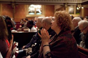 A group of people clapping in a church.