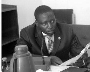 A man in a suit sitting at a desk.