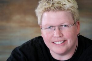 A woman with glasses smiling for the camera.