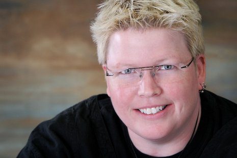 A woman with glasses smiling for the camera.
