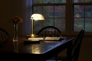 A lamp on a table next to a window.