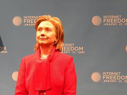 A woman in a red coat and a man in a blue suit stand next to each other.