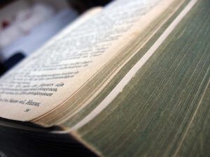 A close up of an old book on a bed.