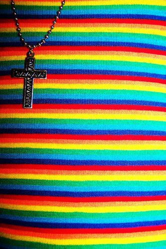A rainbow striped necklace with a cross on it.