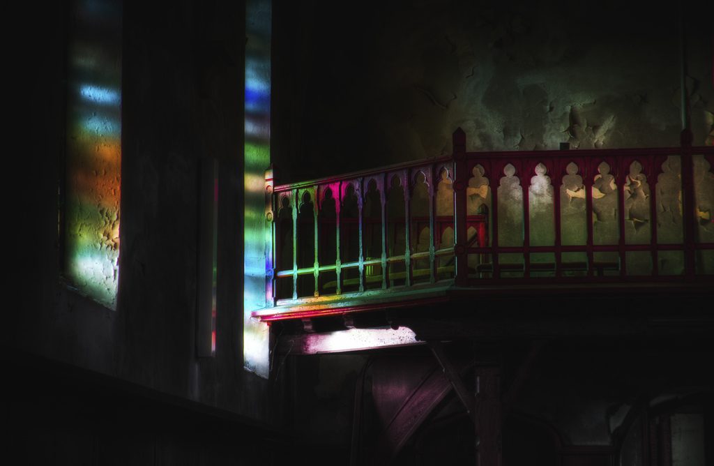 Sunlit colored panes casting rainbow on balcony