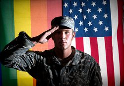 A soldier salutes in front of an american flag.