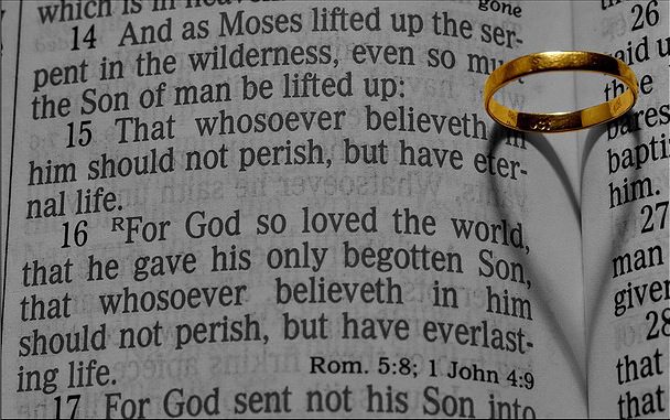 A bible with a ring on top of it.