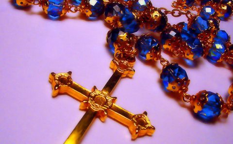 A blue and gold rosary with a gold cross.