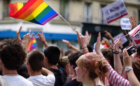 Crowd waving a rainbow pride flag