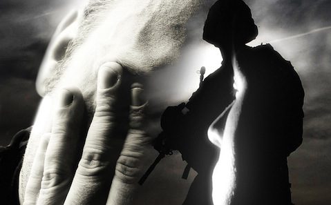 A black and white image of a soldier with his hand on his face.