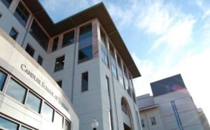 A white building with windows and a blue sky.