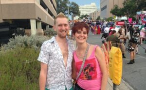 A man and woman standing next to each other at a street fair.