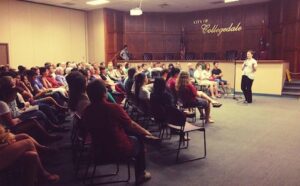 A group of people in a courtroom listening to a speaker.