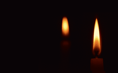Two lit candles on a black background.