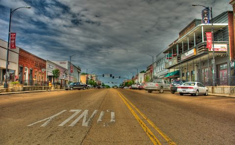 An empty street with cars parked on it.