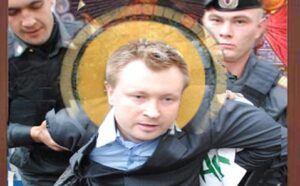 A man in a suit is being escorted by police.