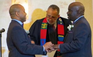 Two men in suits shaking hands at a ceremony.