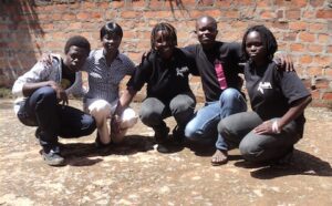 A group of people posing in front of a brick wall.