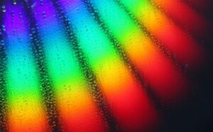 A rainbow of water droplets on a black background.