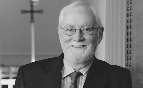 A black and white photo of a man in a suit and tie.