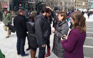 A group of people standing around on a city street.