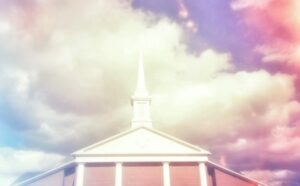 A church with a steeple under a cloudy sky.