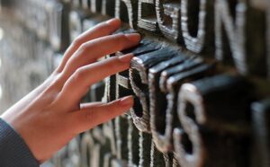 A person's hand is reaching for a piece of metal.