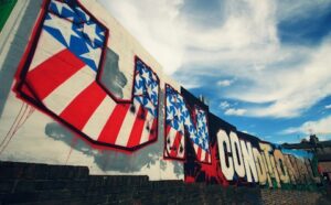 An american flag painted on the side of a brick wall.