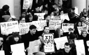 A group of people holding signs in front of a building.