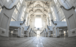 A row of white pews in a church.