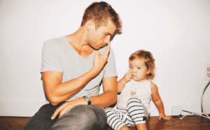 A man and a little girl sitting on the floor.