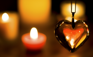 Heart pendant with candles in background.
