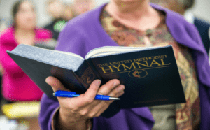 A woman holding a bible in front of a crowd.