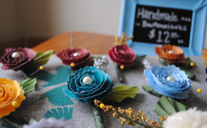Colorful handmade paper flowers with price sign.