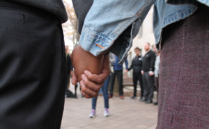People holding hands in a gathering.