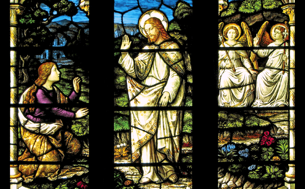 A stained glass window showing jesus and angels.