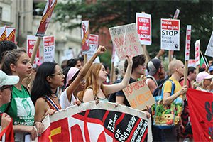 A group of people holding signs on a street.