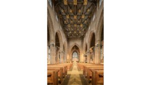The inside of a church with wooden pews.